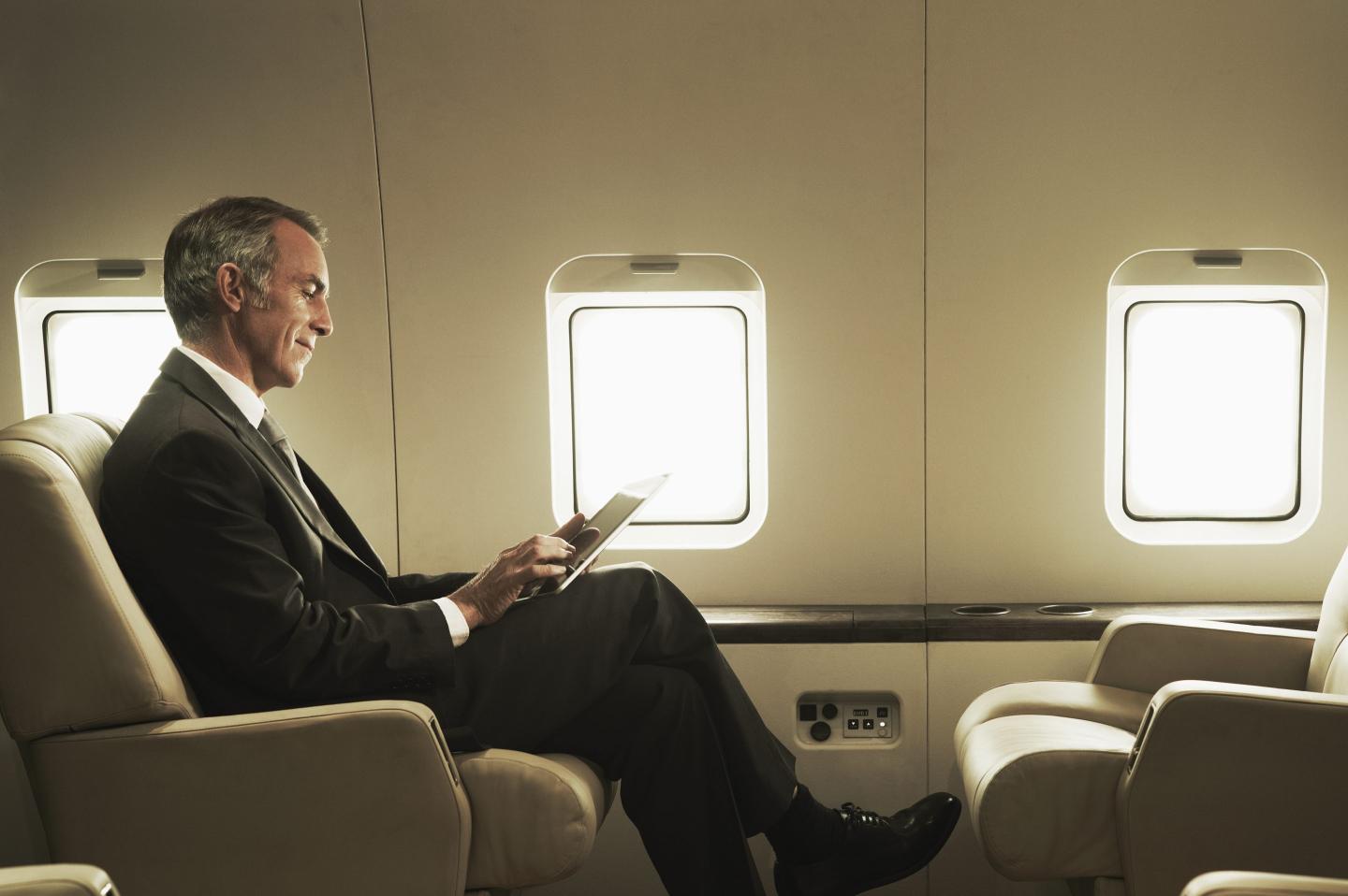 A businessman sits on a private jet.
