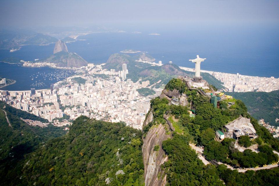 Aerial view of Rio de Janeiro on a sunny day taken from a helicopter. In view are the landmarks Christ the Redeemer and Sugarloaf Mountain.