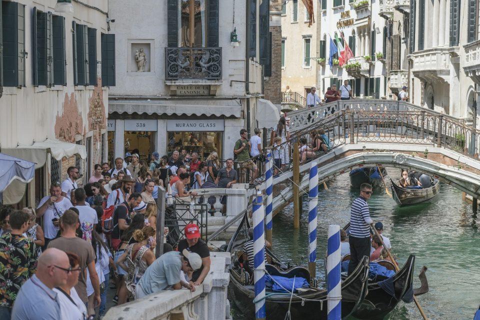 Tourists are crowded near a canal near St. Mark's Square in Venice, Italy. 