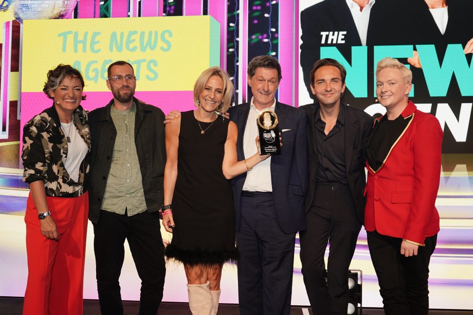 The News Agents's Emily Maitlis (holding the trophy) with Jon Sopel (M) and Lewis Goodall (R).