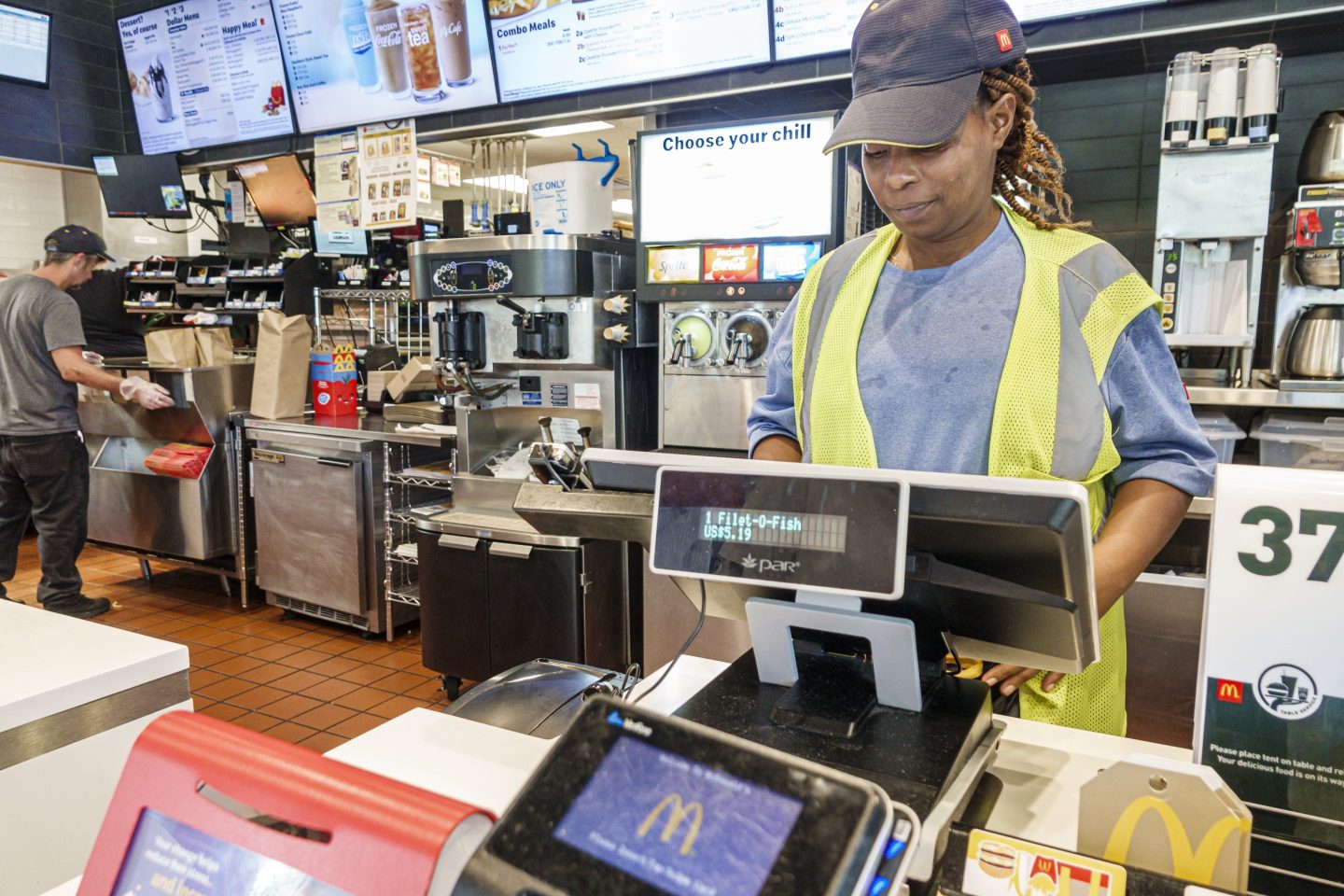 A woman working the cash register at a fast food restaurant