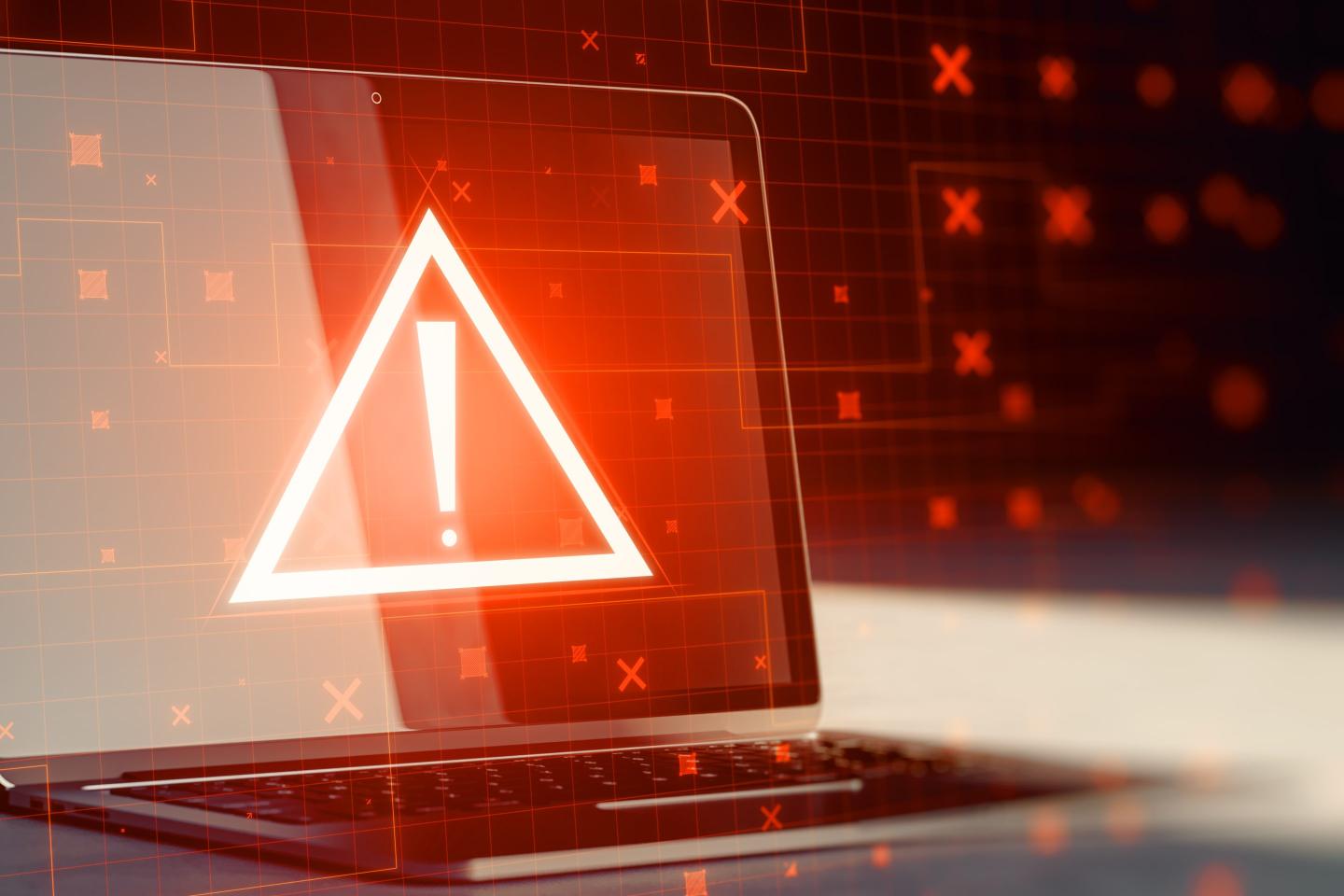 Laptop with creative red security alert on blurry background