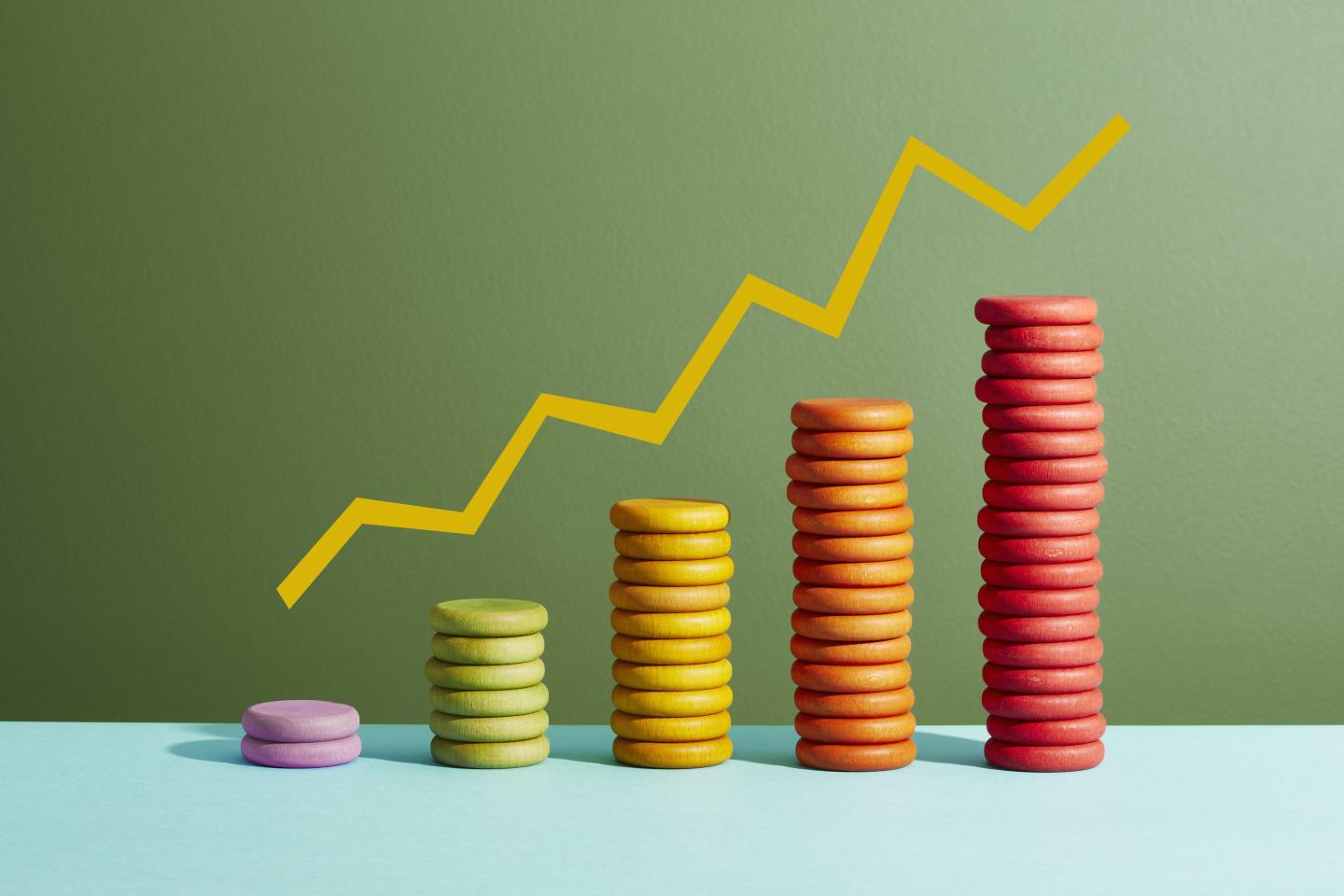 Five stacks of colored coins with a graph line above
