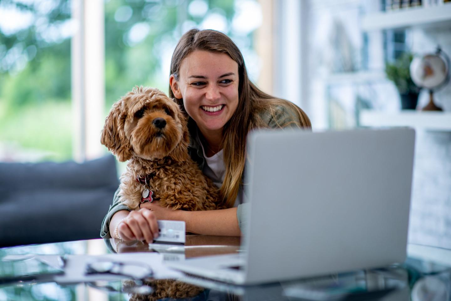 Young woman with her dop at her laptop
