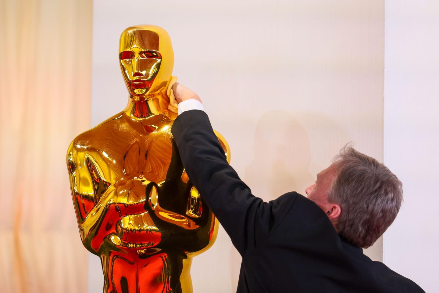 An Oscar statue being cleaned on the red carpet