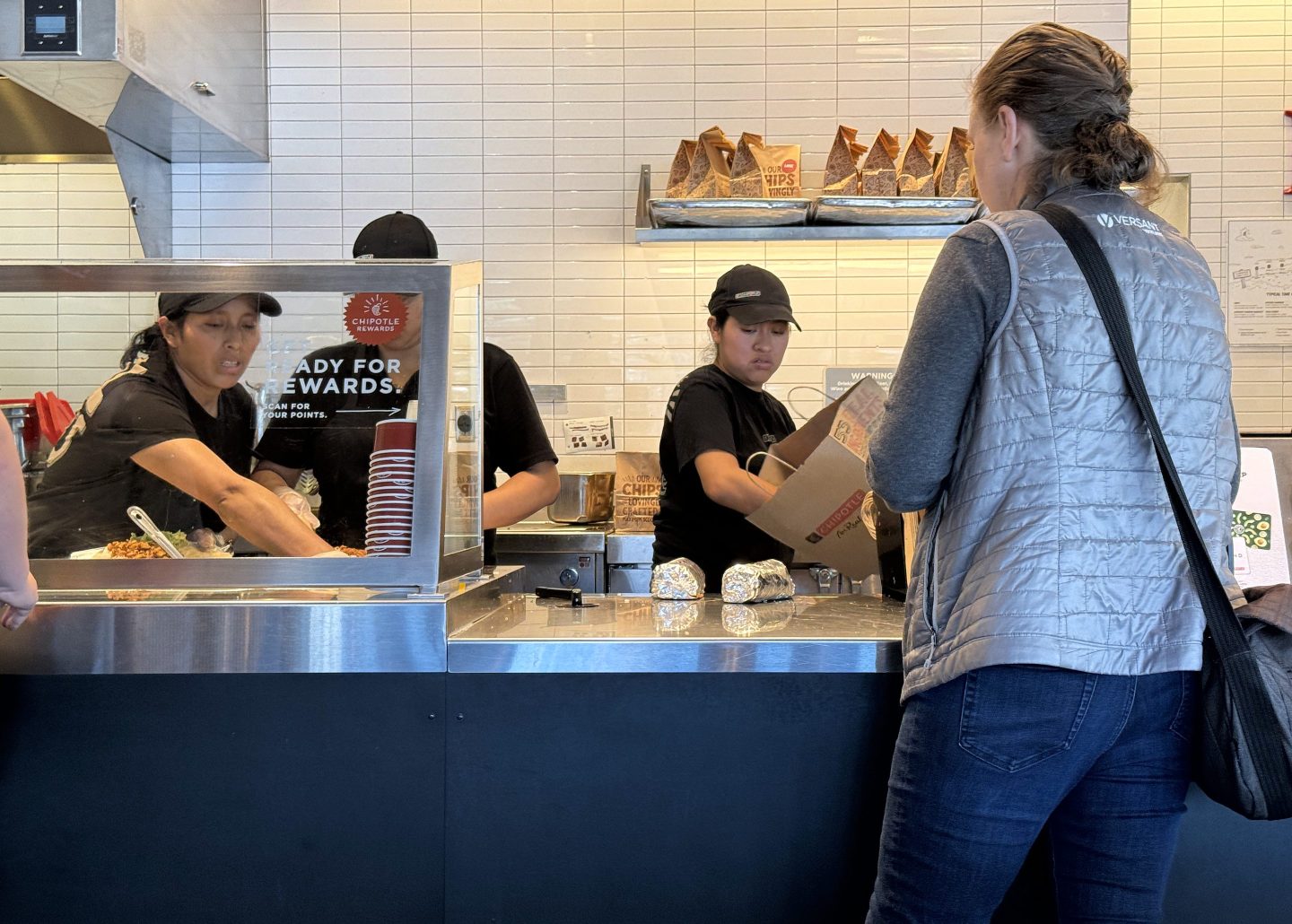 Workers help a customer at a Chipotle restaurant on April 1, 2024, in San Rafael, Calif.