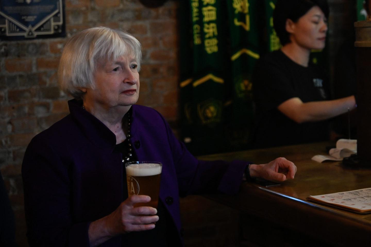 Treasury Secretary Janet Yellen holds a beer