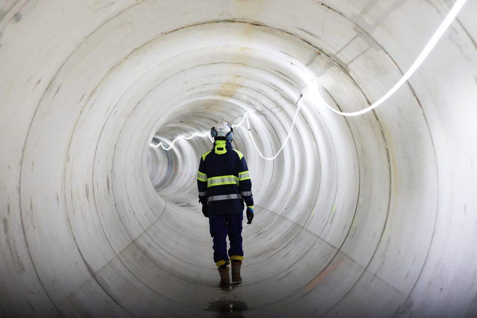 A worker walks inside the water pipeline during a press tour at the Bassin d'Austerlitz, a huge water tank which aims to clean up the Seine River