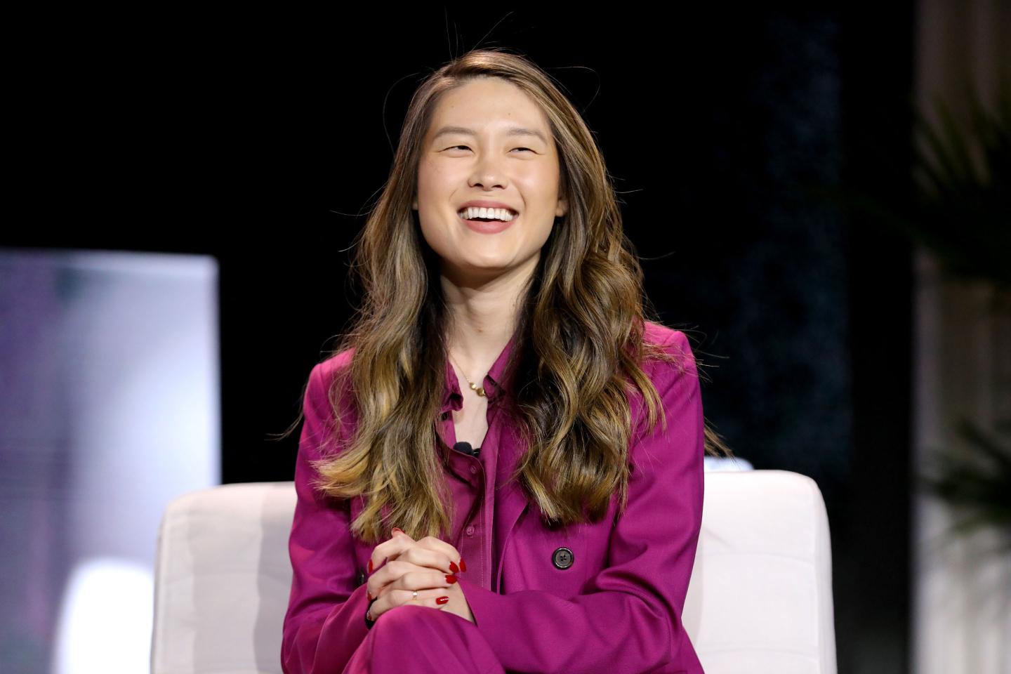 April Koh smiling while sitting onstage