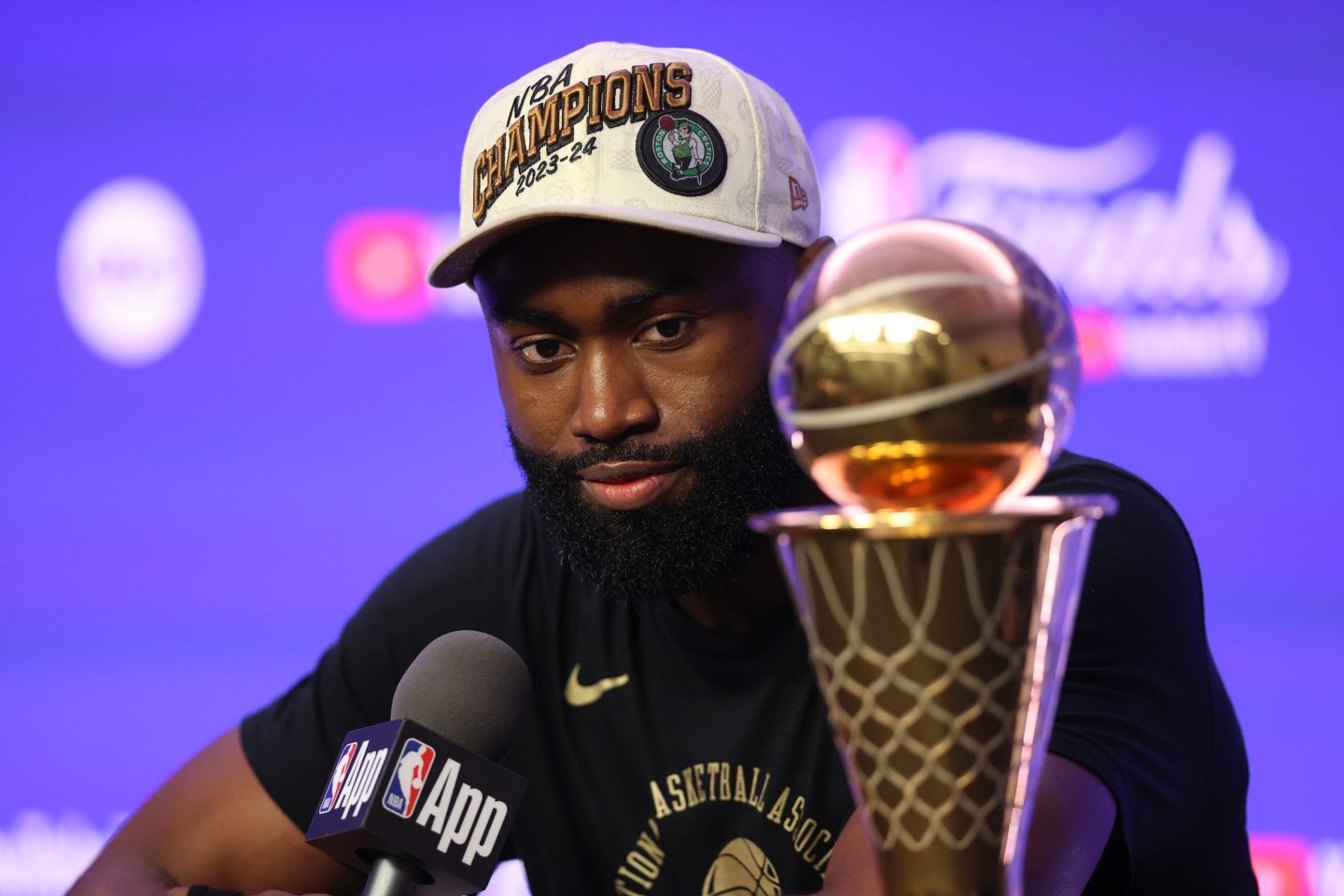 Jaylen Brown seen at a podium with Finals MVP trophy.