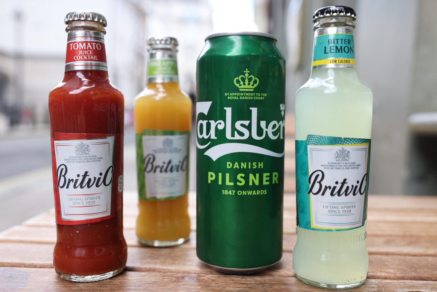 a row of 3 bottles and 1 can lined on a table