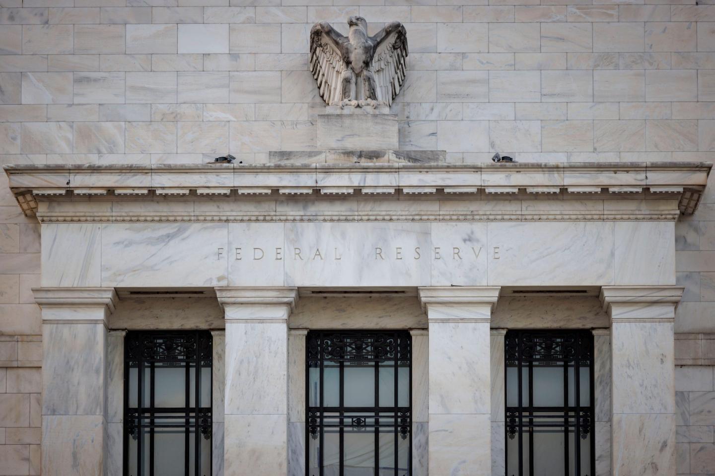A stone sculpture of an eagle over stone arches emblazoned with the words "Federal Reserve."