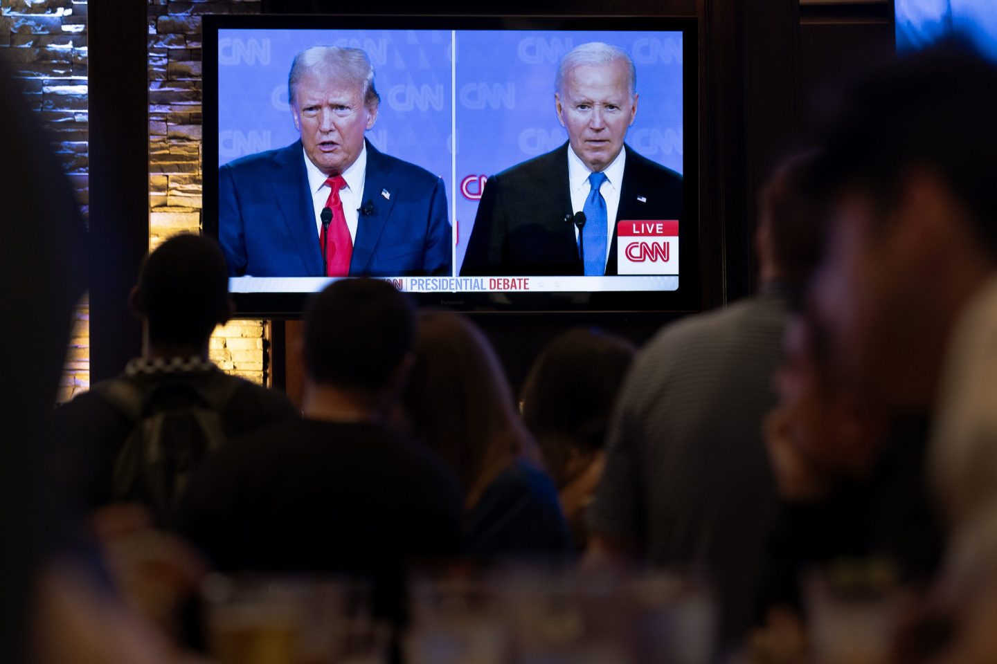 People watch the televised debate between Joe Biden and Donald Trump on June 27 in Chicago.