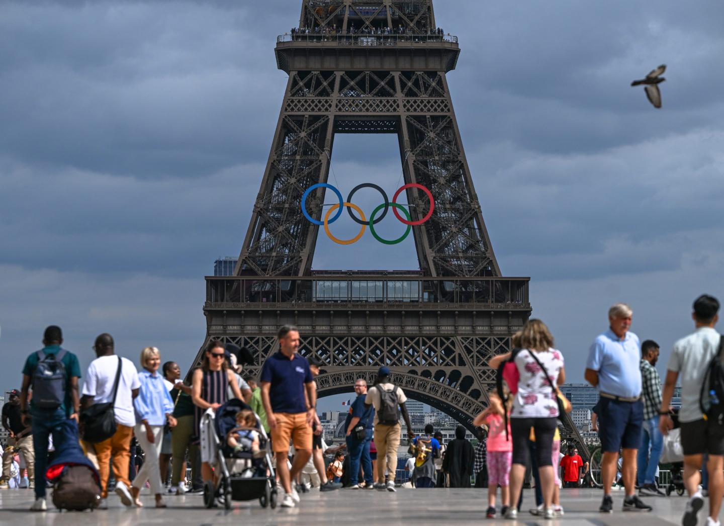 Tourists at Trocadero Plaza admire the Eiffel Tower adorned with Olympic rings, celebrating the upcoming Paris 2024 Olympic and Paralympic Games, on June 30, 2024 in Paris, France.