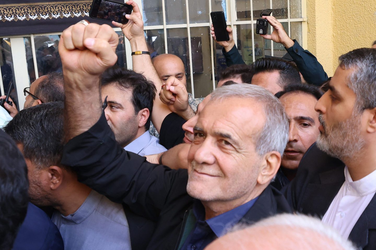 Masoud Pezeshkian holds up fist