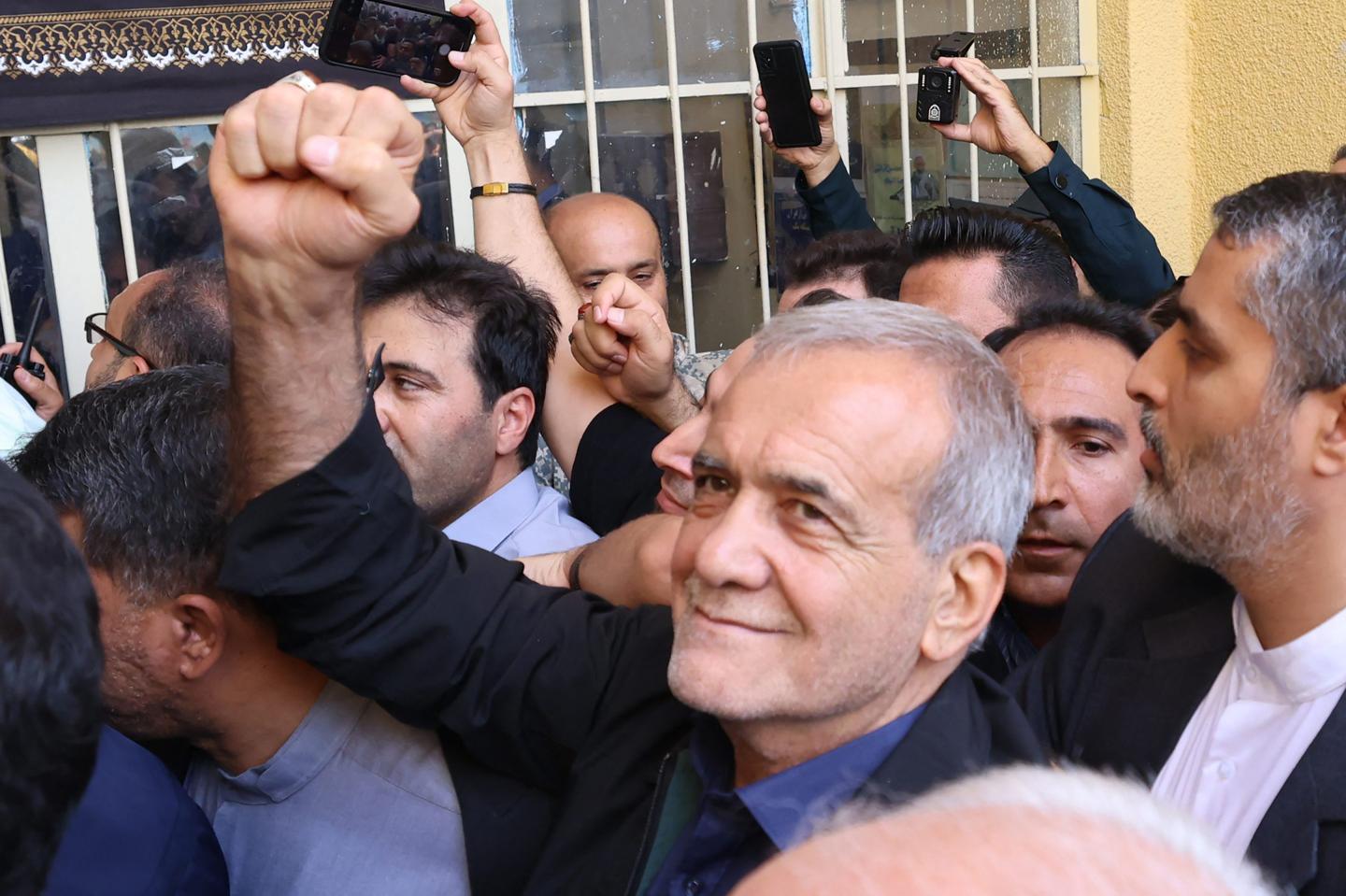 Masoud Pezeshkian holds up fist