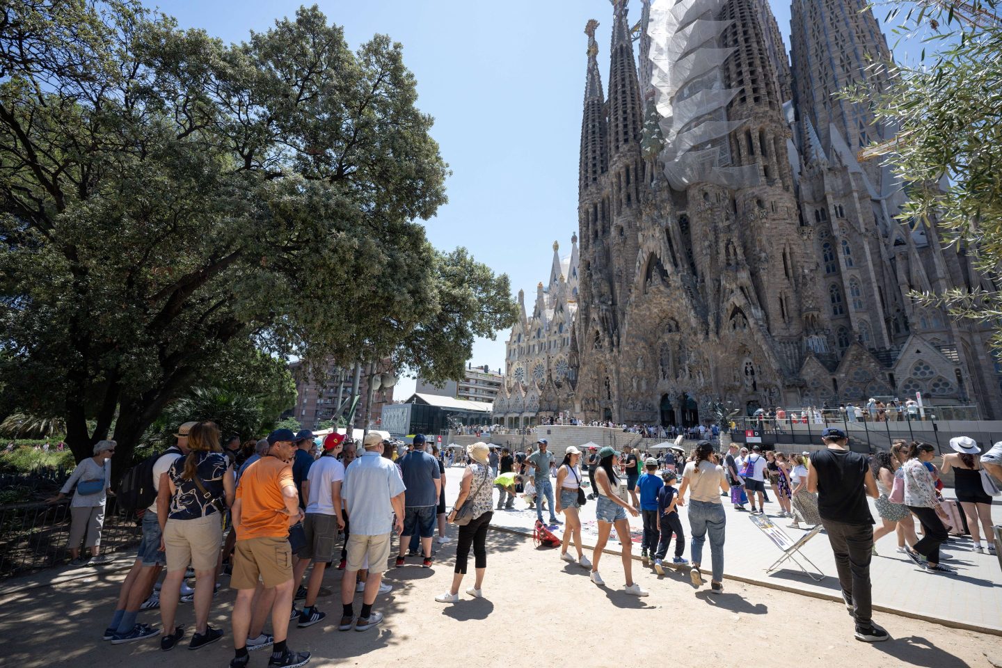 Tourists walk past the Sagrada Familia basilica in Barcelona.