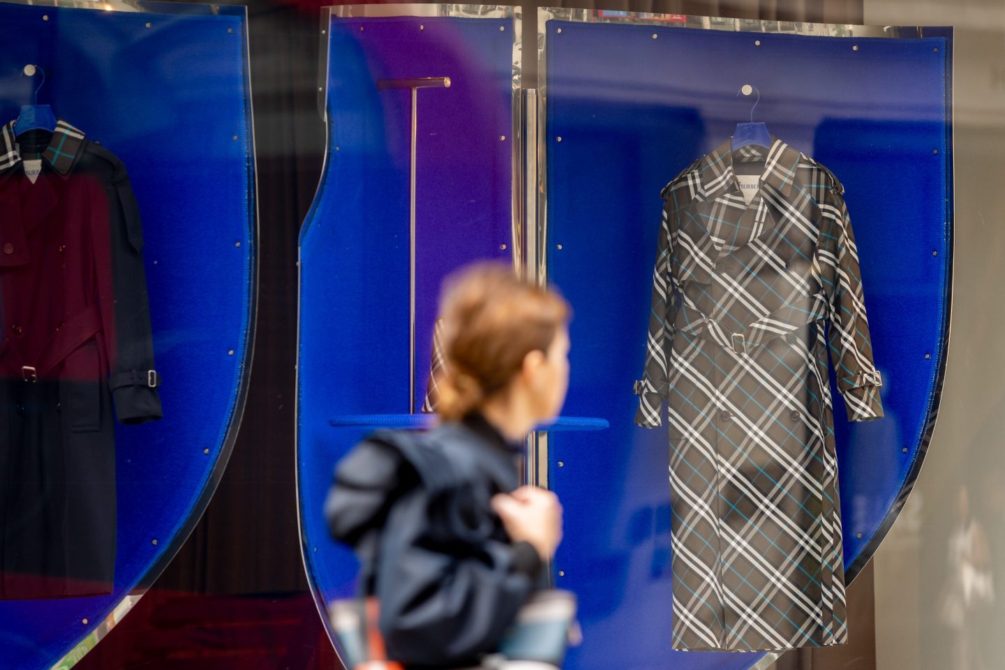 a person looking at a checked jacket at a store window