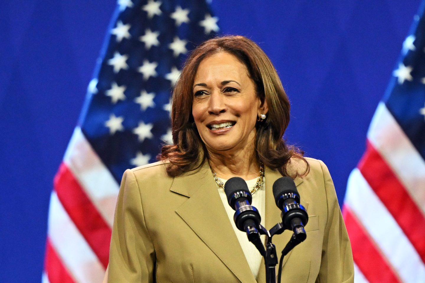 Vice President Kamala Harris stands at a podium in front of an American flag