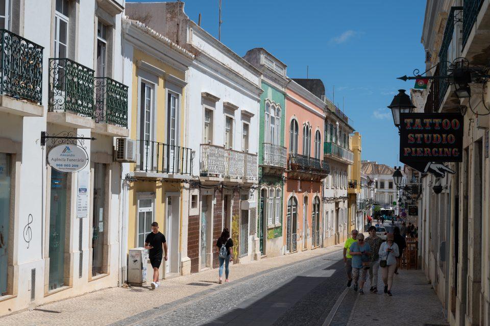 People walking around in a quiet street with colorful houses