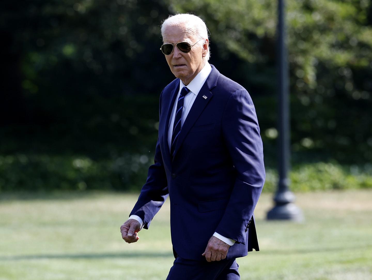 Joe Biden walks with sunglasses on