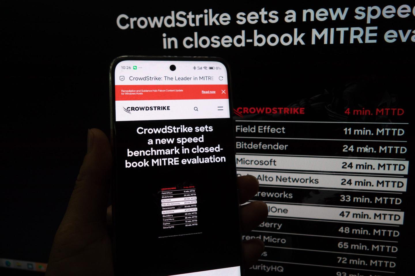 A young man checks the CrowdStrike website page on his mobile phone