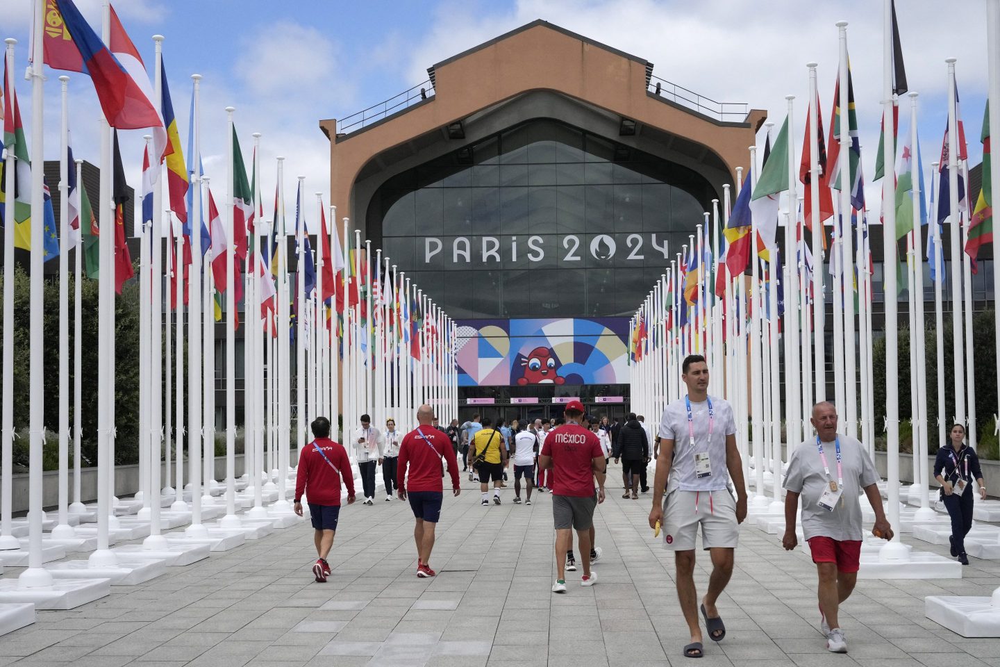 Participants of the Paris 2024 Olympics and Paralympics game walk in front of the cafeteria of the Olympic Village, in Saint-Denis, northern Paris, on July 22, 2024, ahead of the opening ceremony of Paris 2024 Olympic and Paralympic Games.