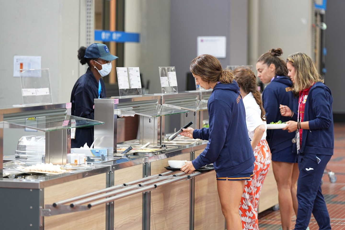 people serving food at a food court