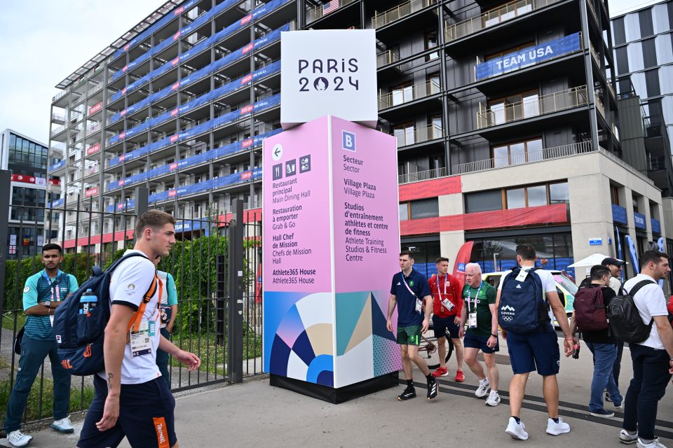 people walking in and out of a big building complex