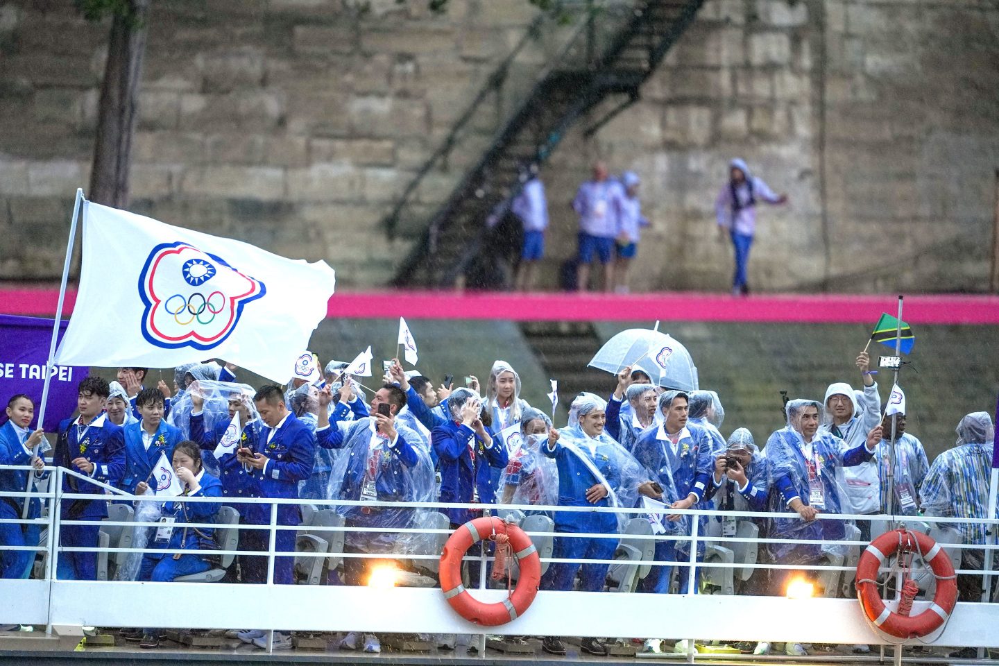 PARIS, FRANCE - JULY 26: Athletes sail in a boat along the river Seine as rain starts at the start of the opening ceremony of the Paris 2024 Olympic Games in Paris, France on July 26, 2024. (Photo by Aytac Unal/Anadolu via Getty Images)