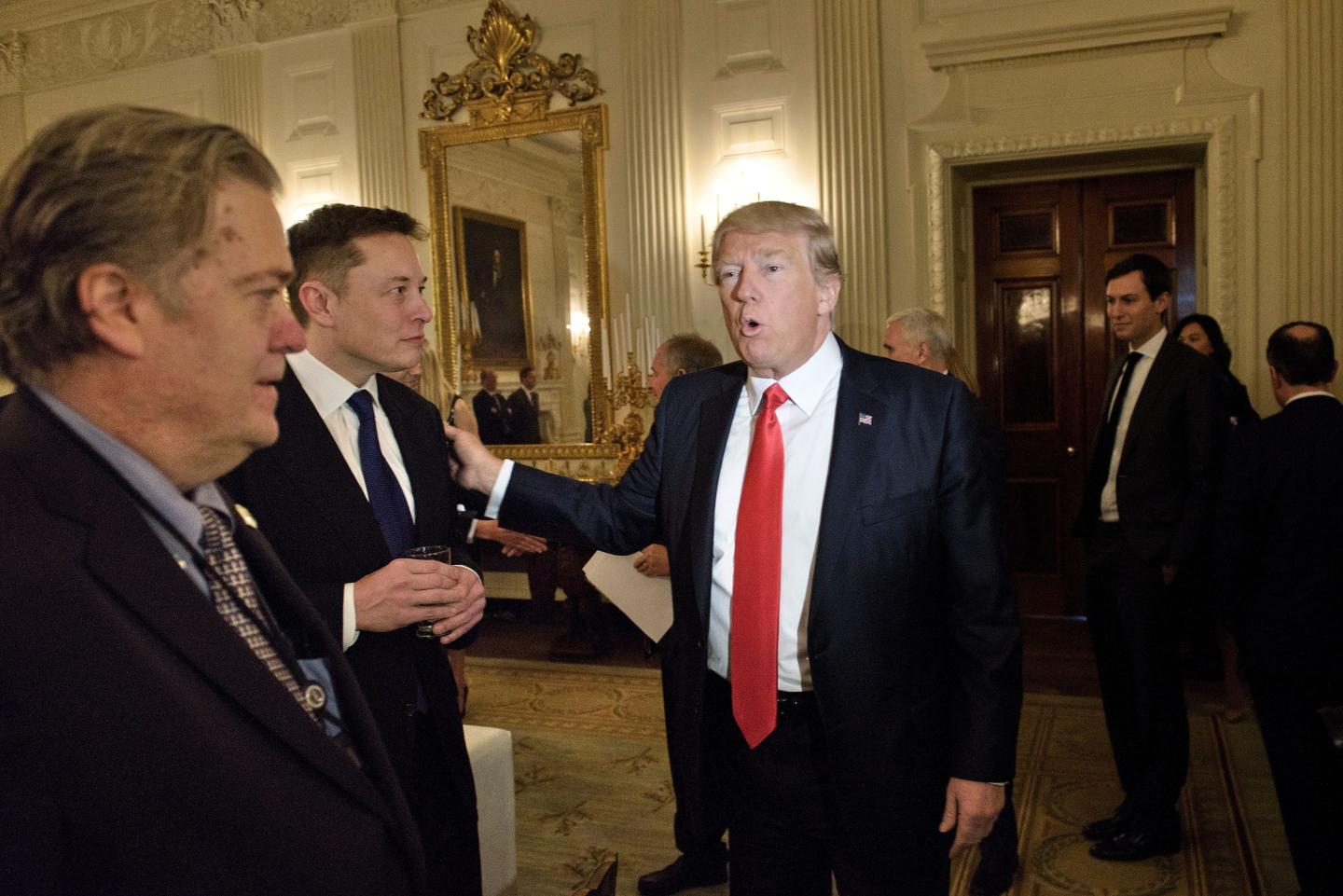 Trump advisor Steve Bannon (L) watches as US President Donald Trump greets Elon Musk, SpaceX and Tesla CEO, before a policy and strategy forum with executives in the State Dining Room of the White House February 3, 2017