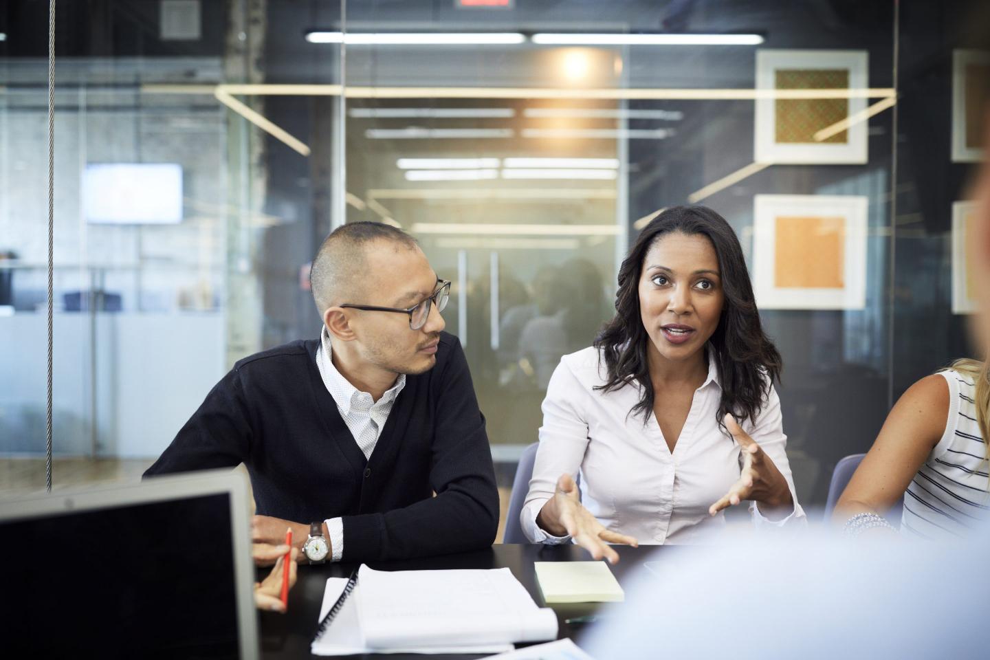 Businesswoman discussing with colleagues in meeting at conference table