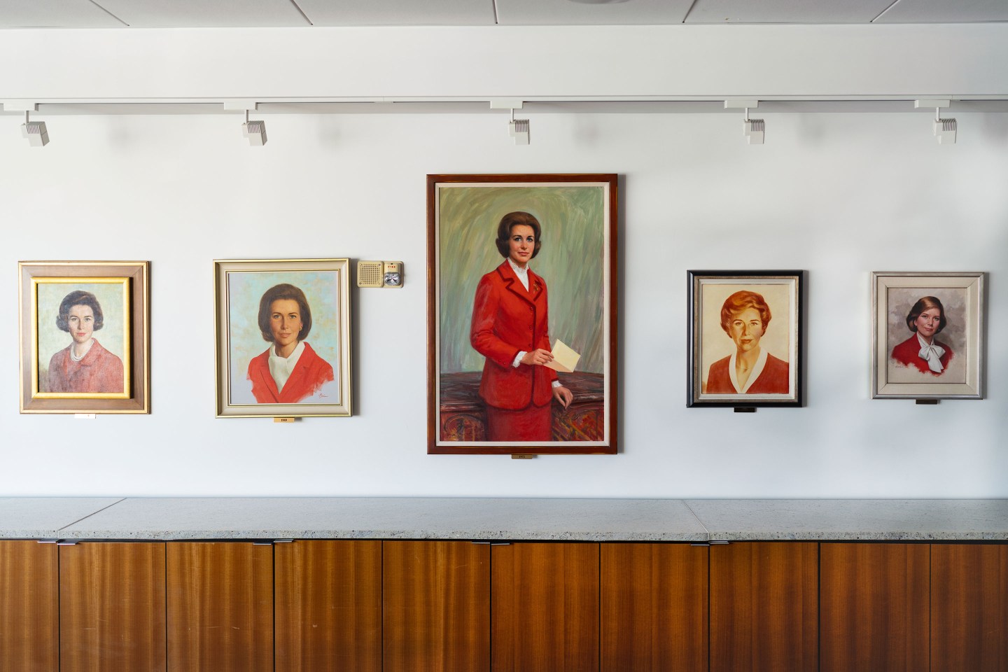 A series of portraits of Betty Crocker hang under lights