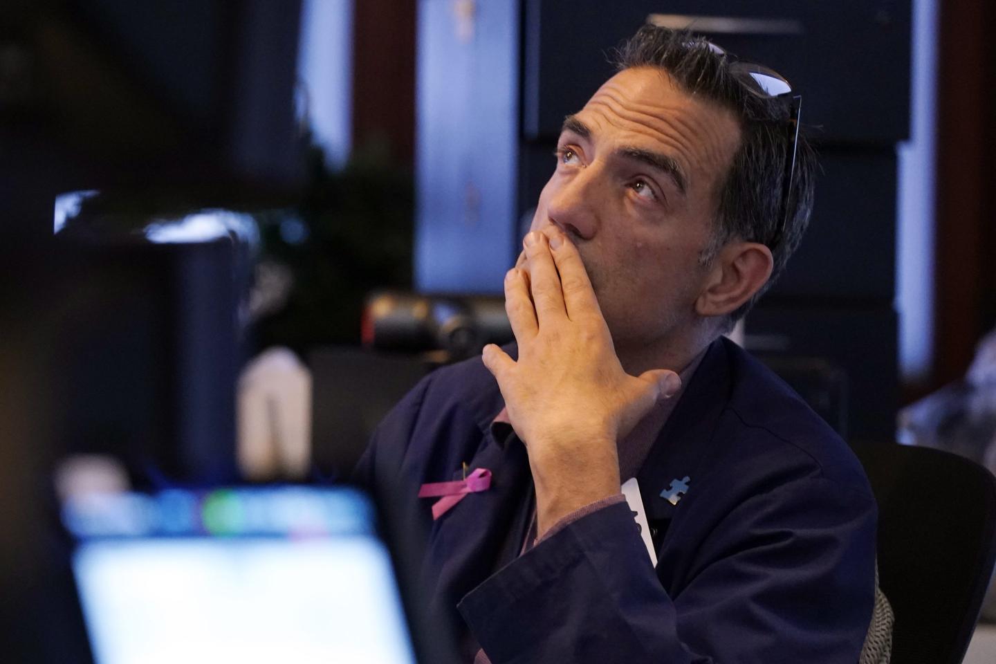 Trader holds hand up to his face