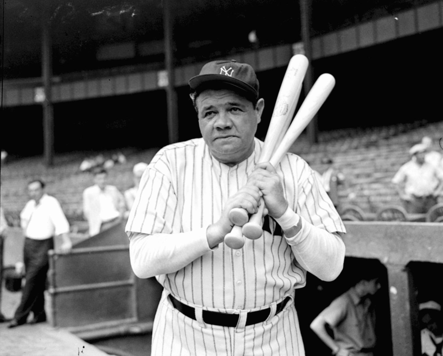 Babe Ruth holding baseball bats