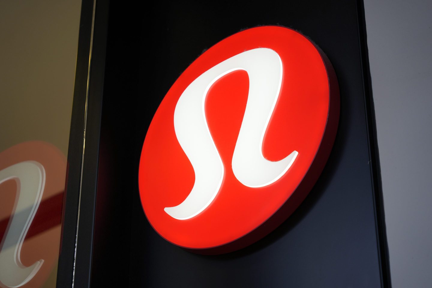 The logo of Lululemon in a store window