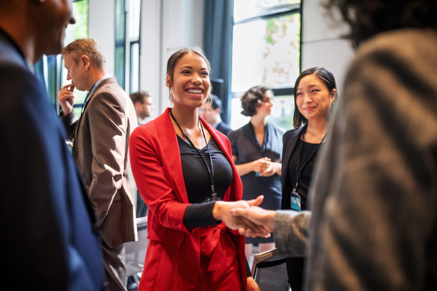 Businesswoman shakes the hand of someone at a networking event