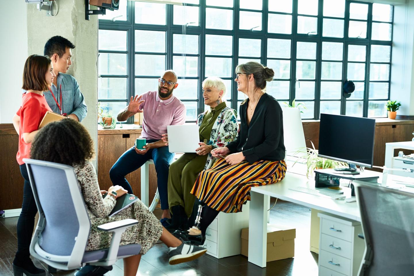 business coworkers gathered around a desk in an informal meeting