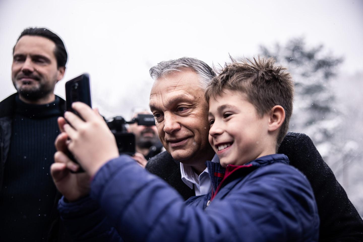 Viktor Orban, Hungary's prime minister, takes a selfie photograph with a boy, after voting at a polling station in Budapest, Hungary, on Sunday, April 3, 2022. Prime Minister Viktor Orbans party was tied with the opposition in a poll published a day before Hungarys election, raising the possibility that the race will be even tighter than previously predicted.
