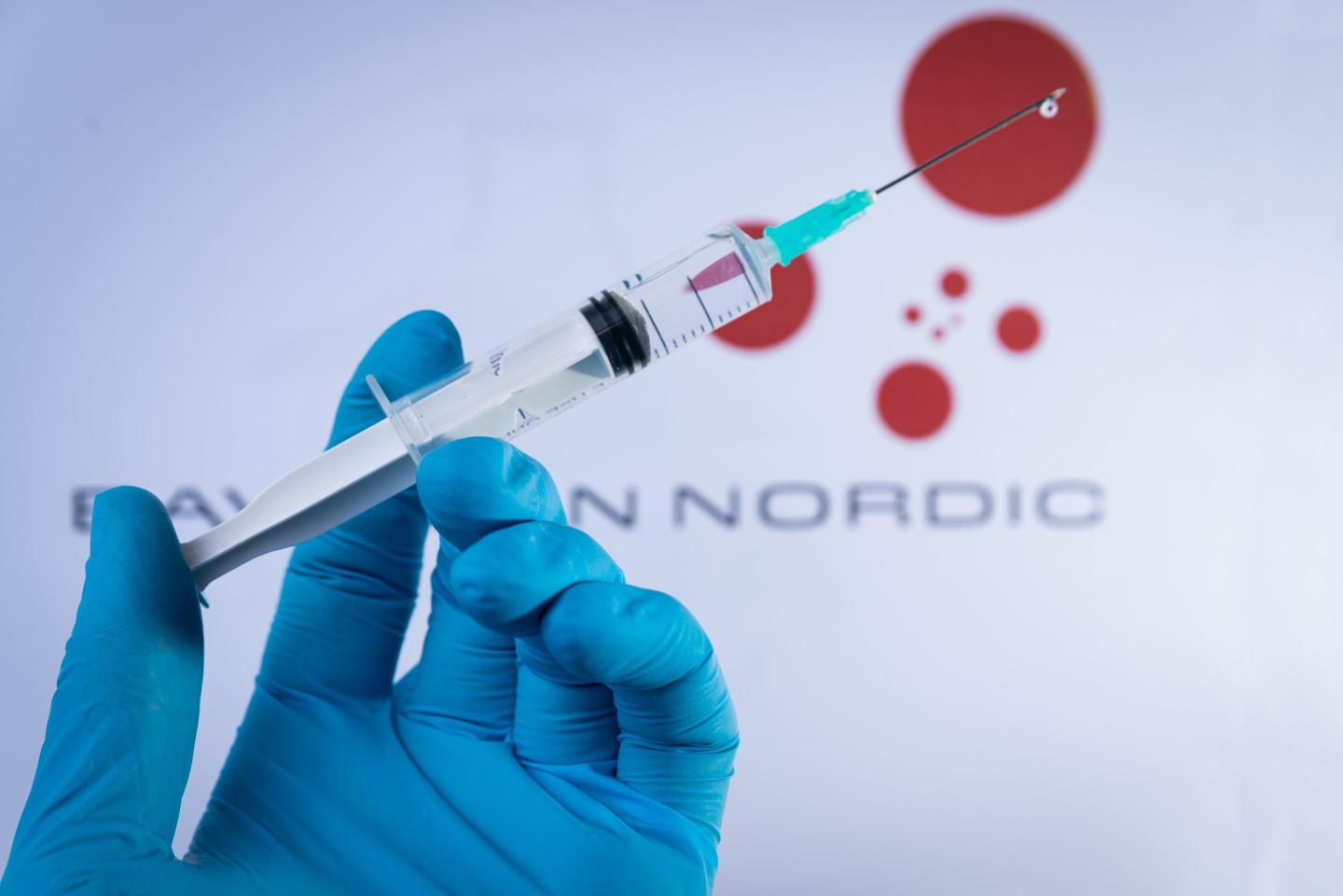 person's hand holding a syringe