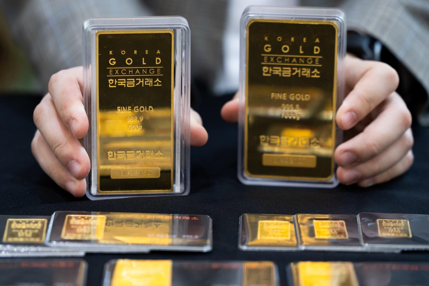 hands holding gold bars