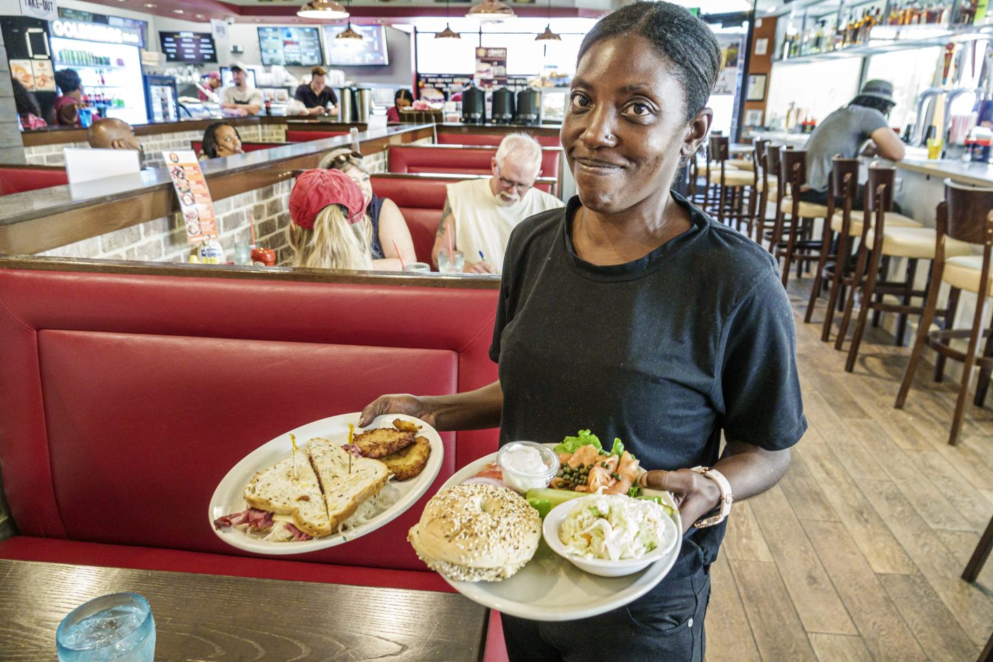 A waitress carrying two plates of food