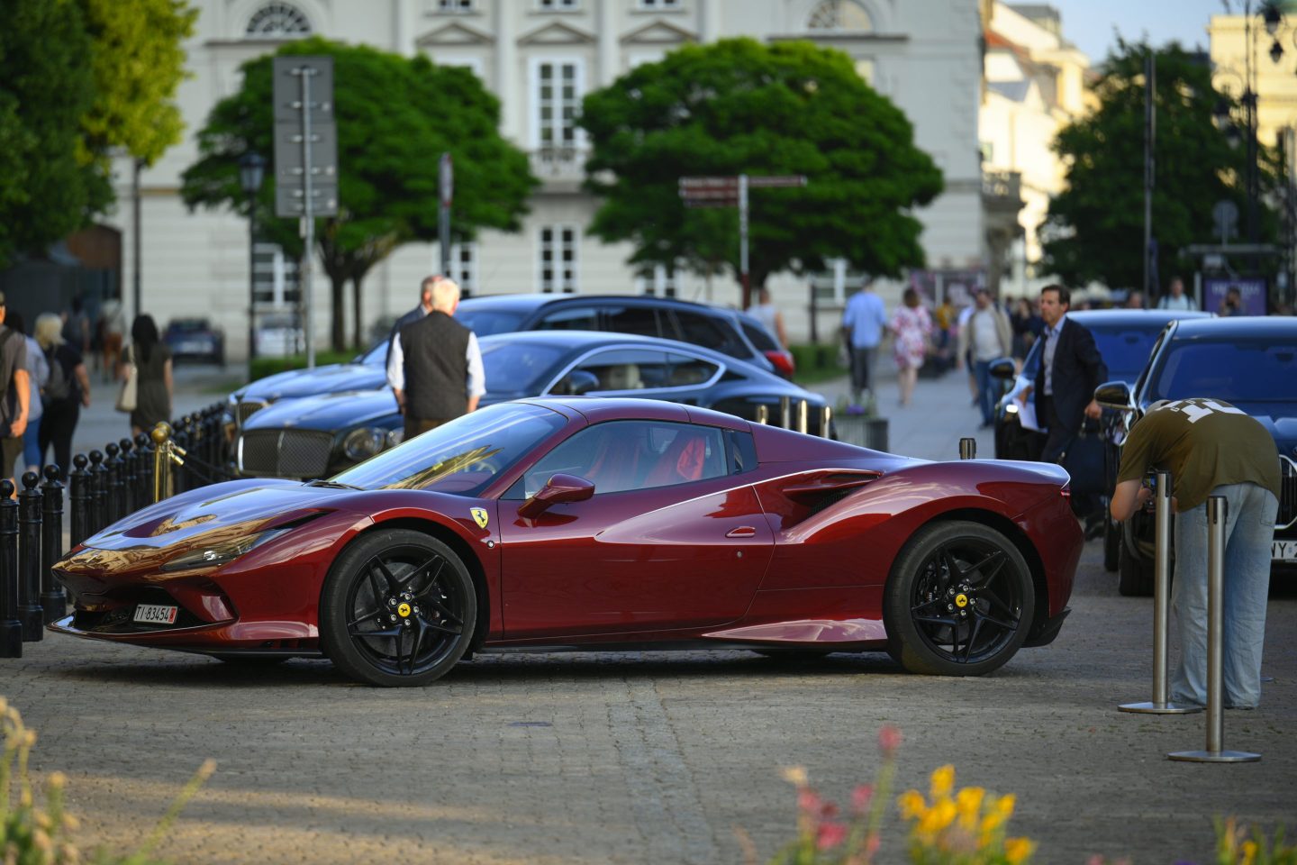A man is seen taking a photo with his mobile phone of a Ferrari F8 in Warsaw, Poland on 21 May, 2024. (Photo by Jaap Arriens/NurPhoto via Getty Images)