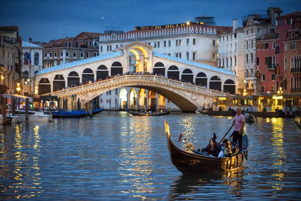 people sitting on gondalas in Venice's canals