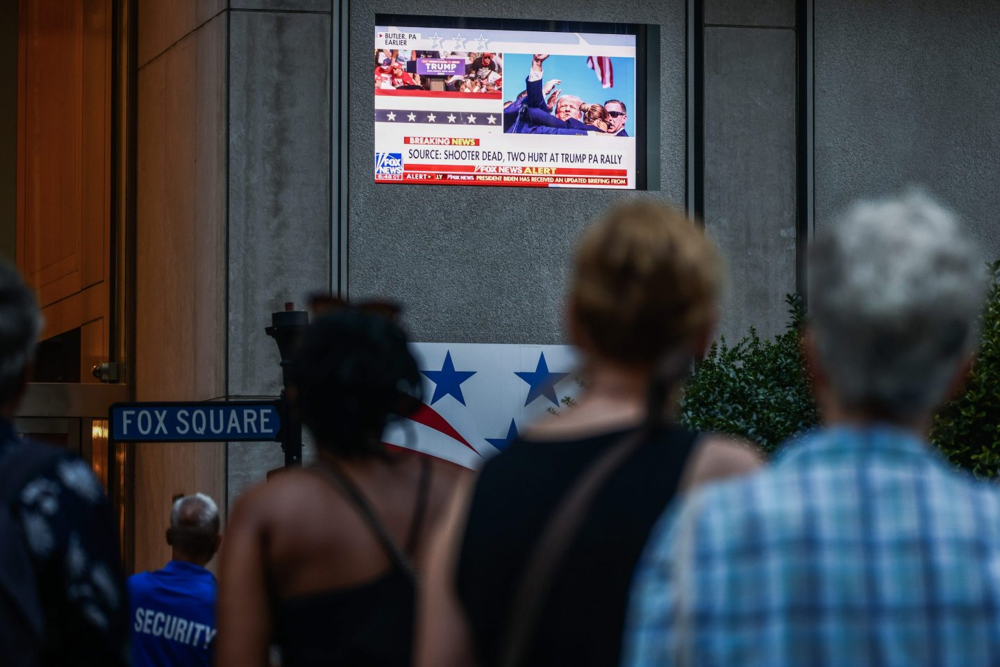 People watch the news in front of the Fox News building in Manhattan after a shooter targeted former U.S. President Donald Trump at a campaign rally in Pennsylvania on Jul. 13.