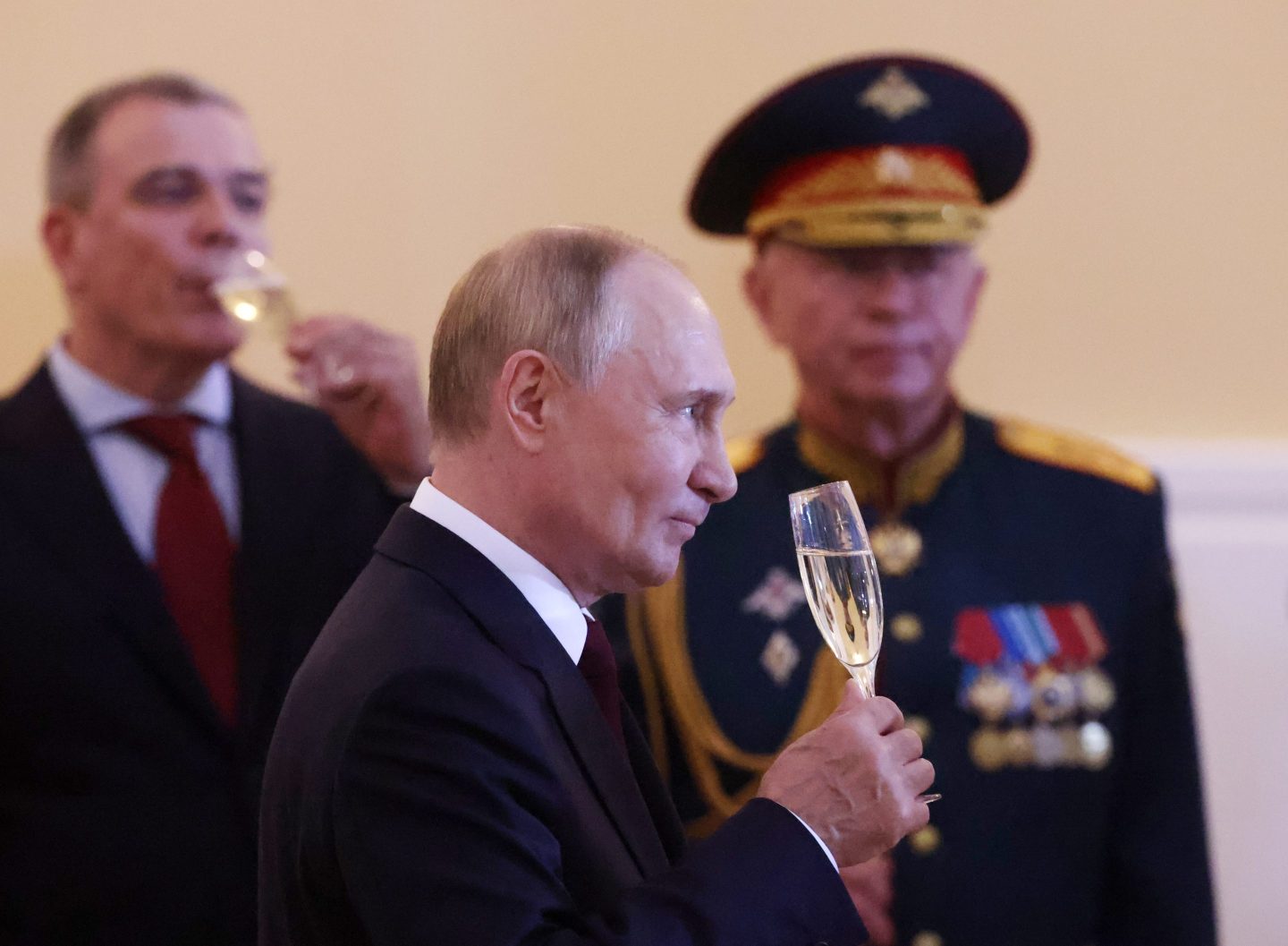 Russian President Vladimir Putin drinks champagne as Deputy Defence Minister Alexander Fomin looks on during a reception for Naval officers after a military parade on Jul. 28 in Saint Petersburg,