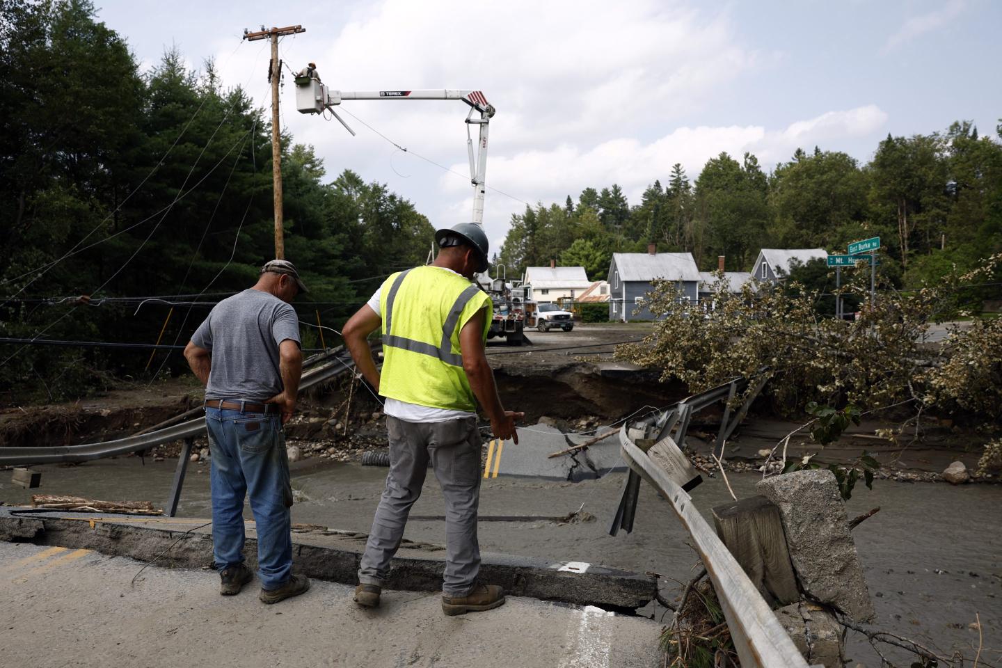Workers survey the damage on East Burke Road after flash floods