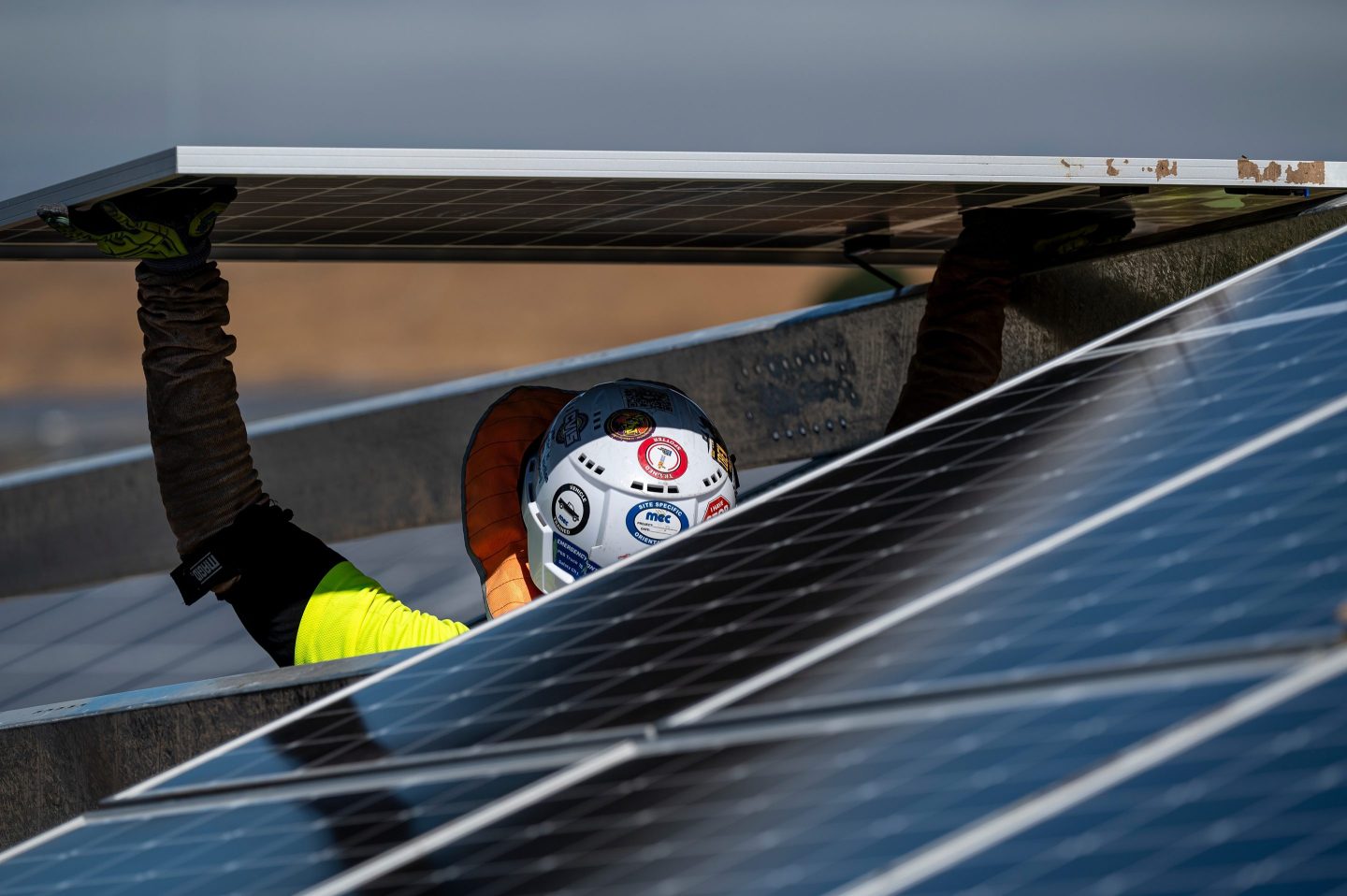 Construction worker behind solar panel