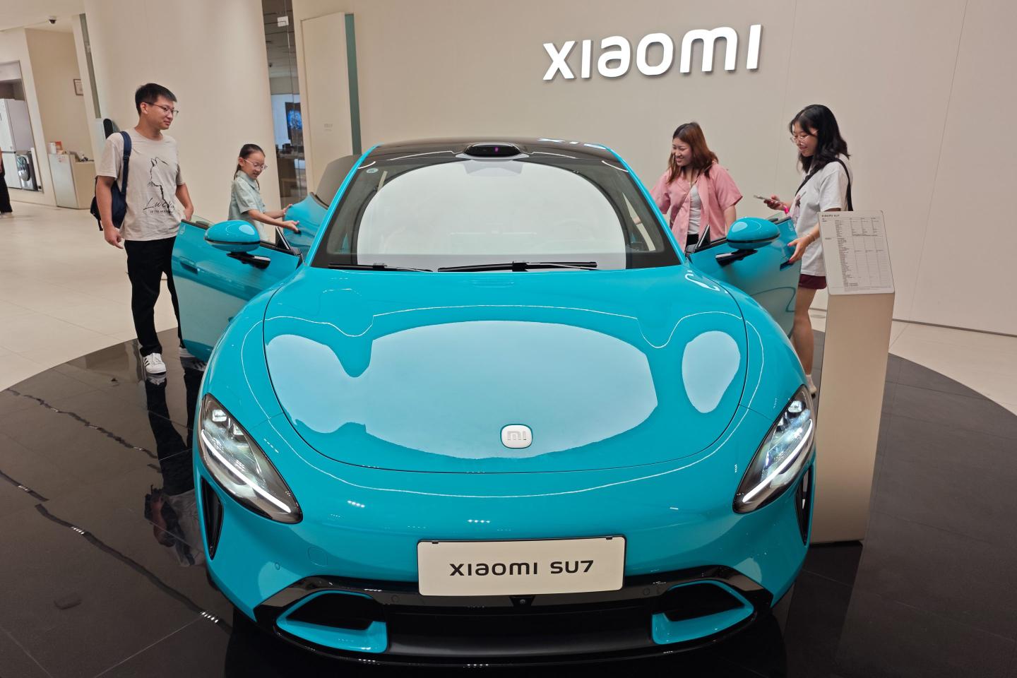 Customers experience the Xiaomi SU7 vehicles at the Xiaomi flagship store in Shanghai, China, August 1, 2024.