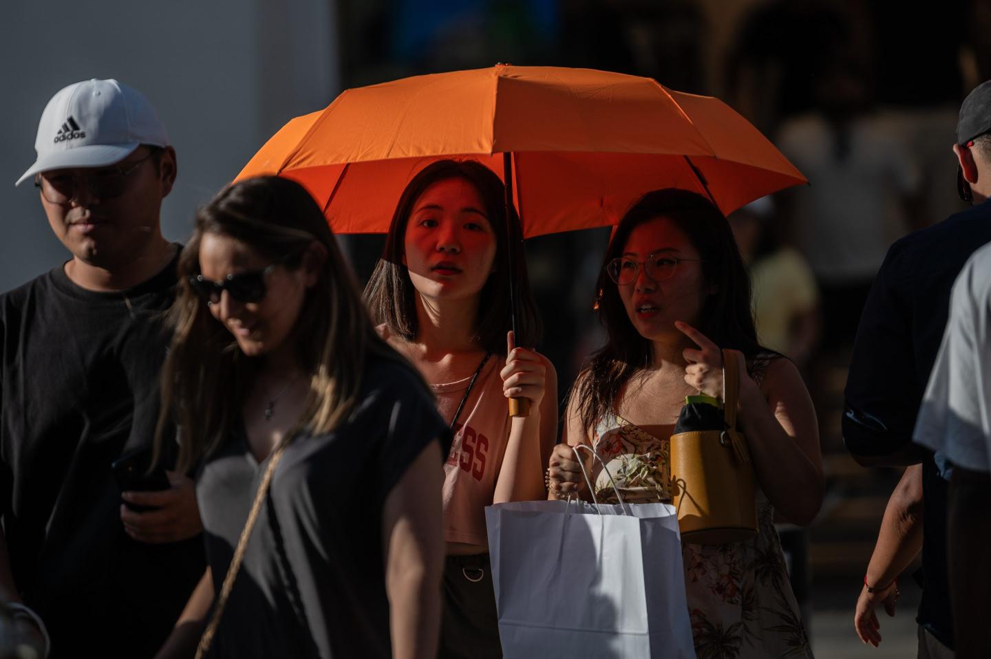 MADRID, SPAIN - 2024/08/10: Tourists protect themselves from the sun with an umbrella during a hot summer day. Madrid is registering high temperatures of more than 40 degrees Celsius during a summer heat wave. (Photo by Marcos del Mazo/LightRocket via Getty Images)